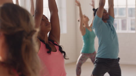 Schöner-Yoga-Kurslehrer,-Der-Junge-Gruppen-In-Kriegerpose-Unterrichtet-Und-Einen-Gesunden-Lebensstil-Genießt-Und-Im-Studio-Bei-Sonnenaufgang-Trainiert