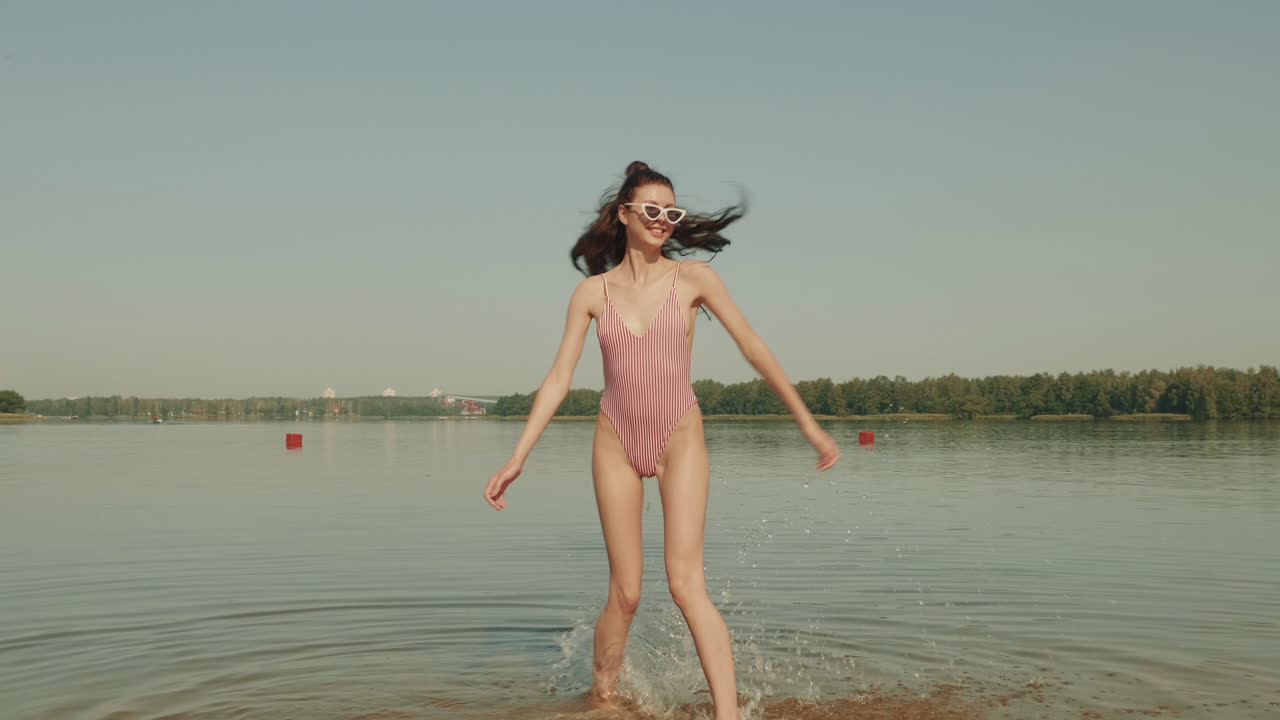 강 의 분홍색 줄무 수영복을 입은 여자