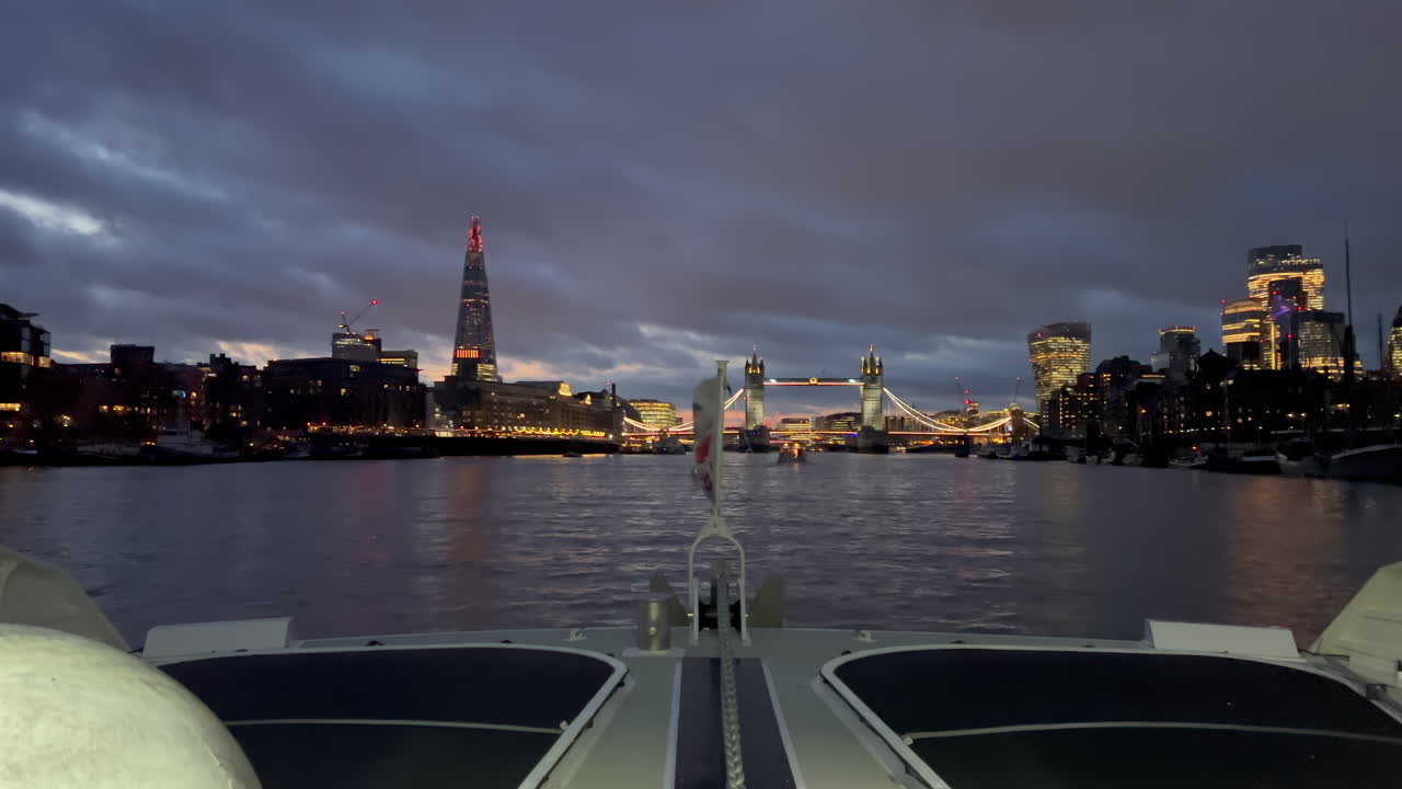 The flag of the United Kingdom waving on a boat moving on the Thames River in the evening in London, England