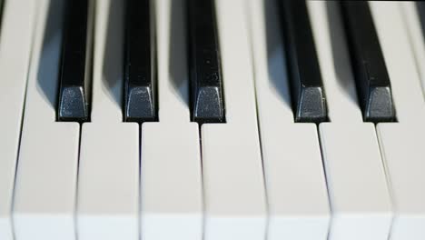 piano keys in a close up, medium speed, tracking shot from right to left