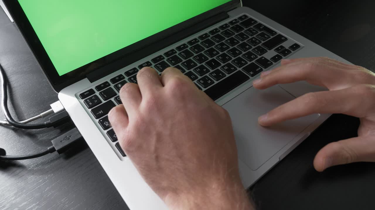 persona está usando chroma key pantalla verde computadora portátil. concepto de tecnología. hombre de negocios está trabajando en la pc en el lugar de trabajo, escribiendo en el teclado. hombre está usando computadora portatil con pantalla verde portátil
