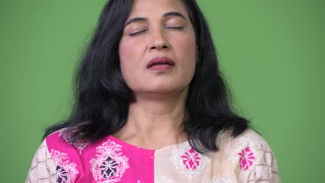 mujer india hermosa madura relajándose con los ojos cerrados