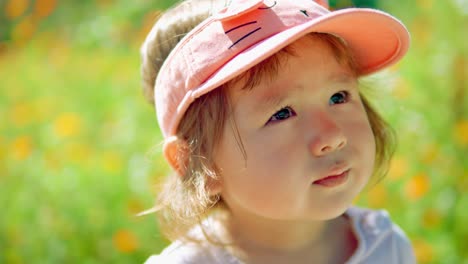 Niña-Pequeña-Esperanzada-Mirando-Hacia-El-Cielo-Y-Bostezando-Parada-En-El-Campo-De-Flores-En-El-Campo---Primer-Plano-De-La-Cara