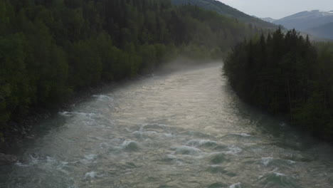 flight over a foggy river. the mist is hanging low over the landscape creating a dark mystical mood over the whole scene