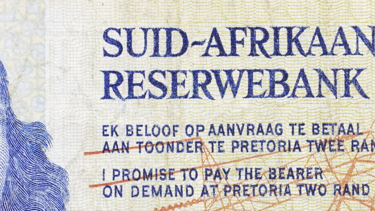 Macro slow pan over South African Reserve Bank text on a vintage two rand note