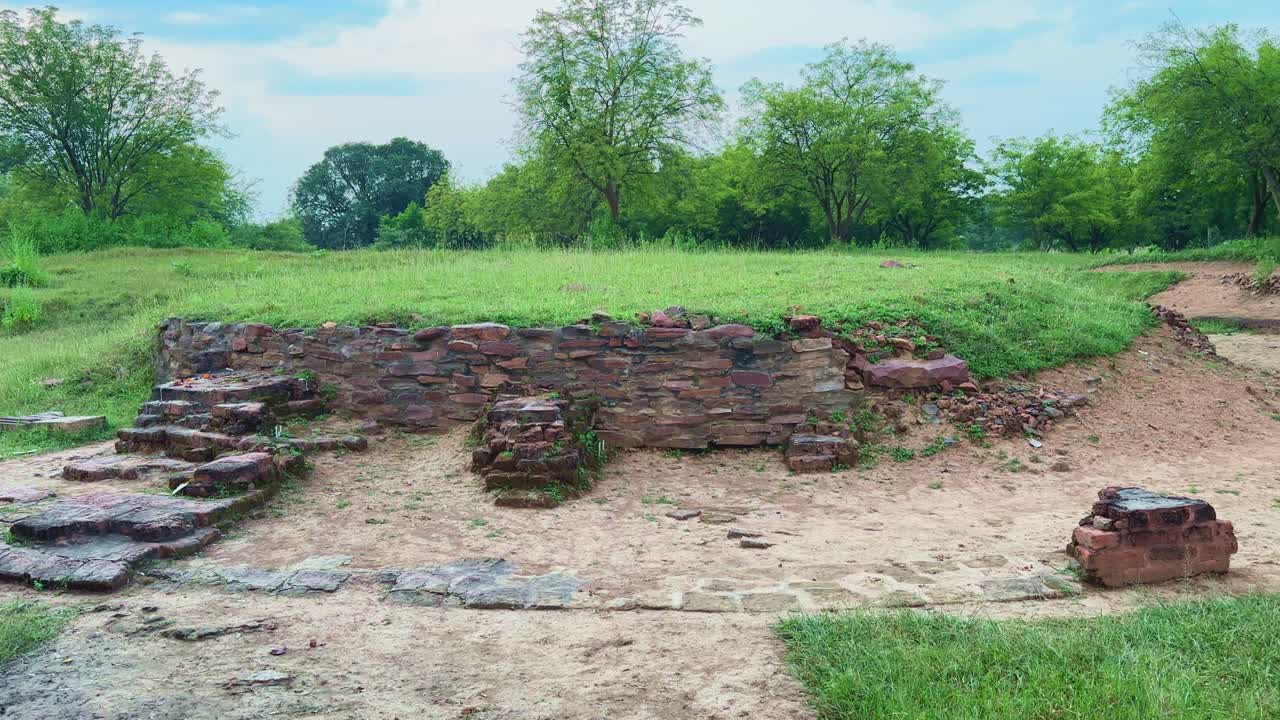 A tilt-up shot revealing the excavated brick and stone foundation of the ancient Bharhut Stupa in Madhya Pradesh, showcasing remnants of its circular base from the Shunga period