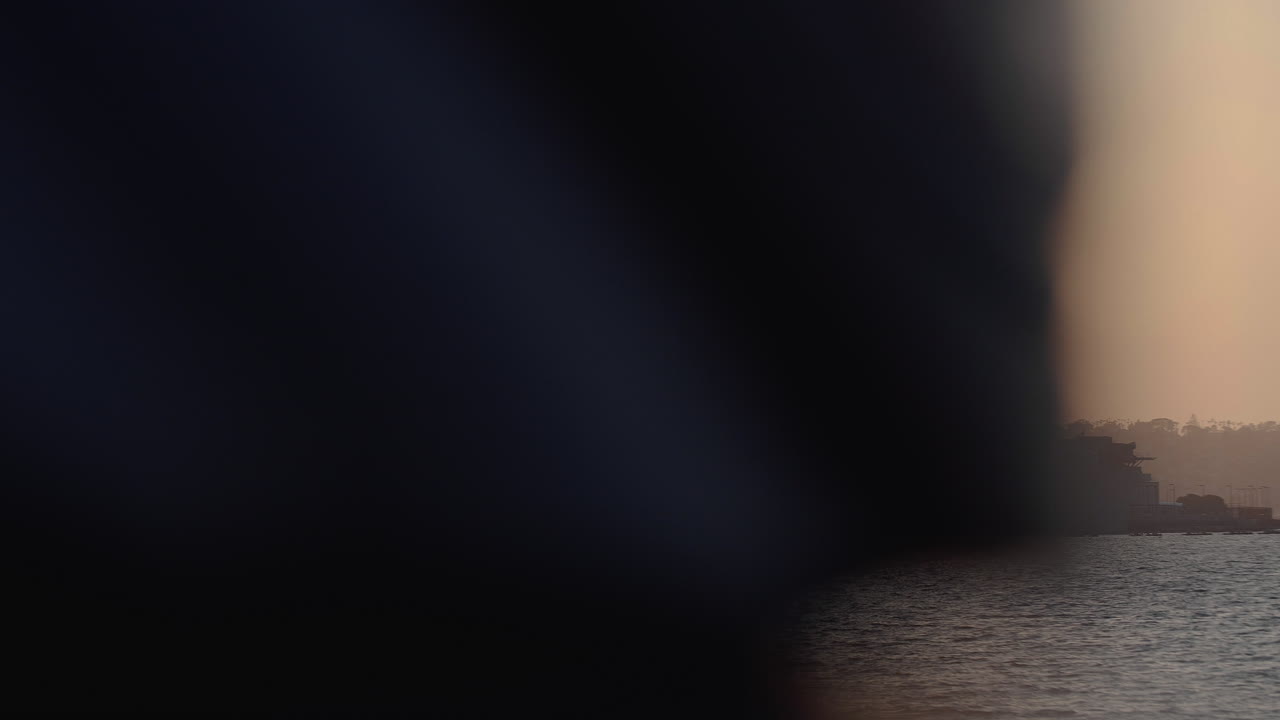 Handheld, slider shot of naval ship docked in the San Diego harbor sunset