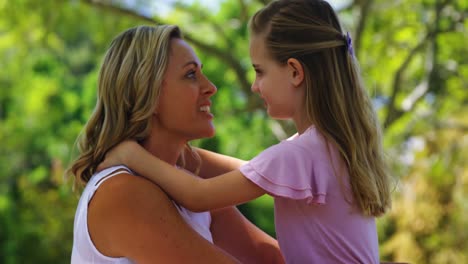 madre feliz abrazando a su hija en el parque 4k