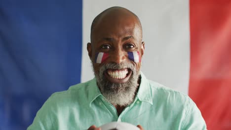 Video-of-happy-african-american-man-with-flag-of-france-holding-soccer-ball