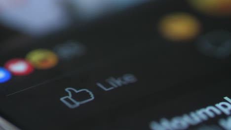 macro dedo tocando como botón para mostrar la reacción en facebook en el teléfono inteligente