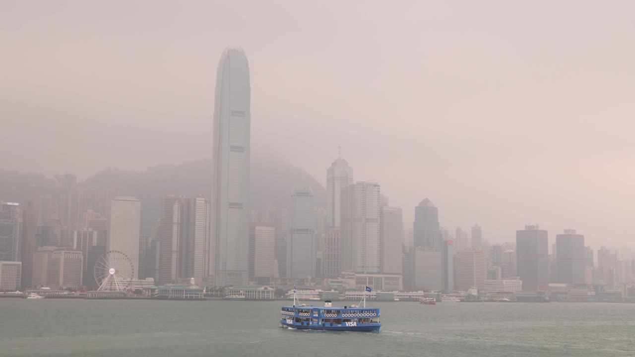 Boat crossing Hong Kong bay river with skyline in background