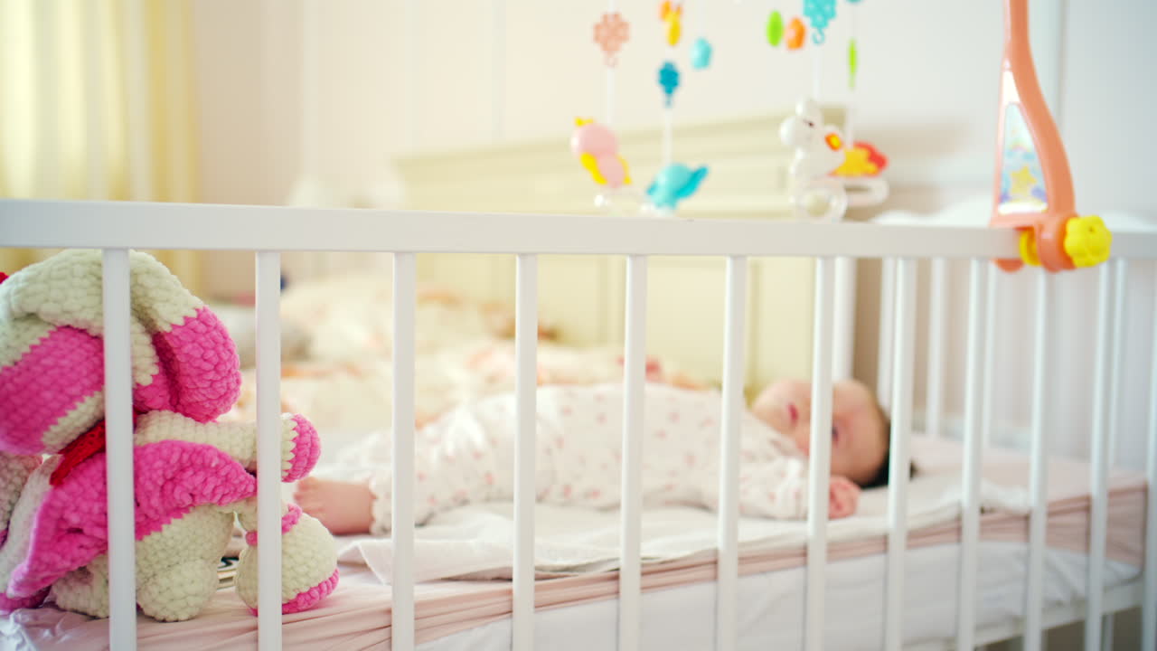 Neonato sereno che dorme nella culla in una luminosa cameretta.