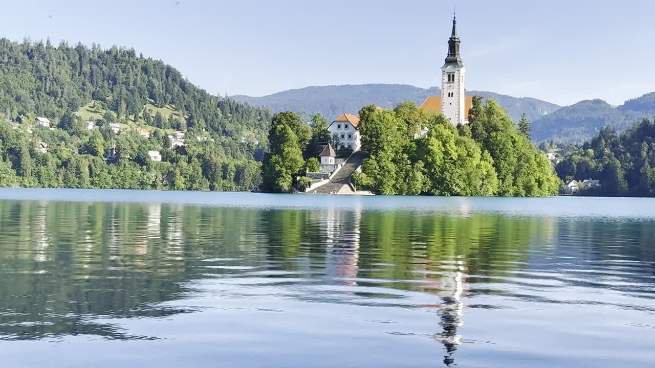 Hypnotising reflections looking towards Lake Bled Island with Church spire on a wonderful clear skies