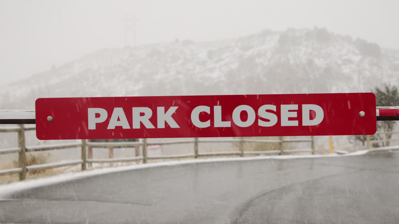 Close up of Park Closed sign in winter snow storm