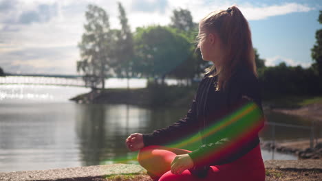 girl practicing yoga and meditation in lotus pose on seaside