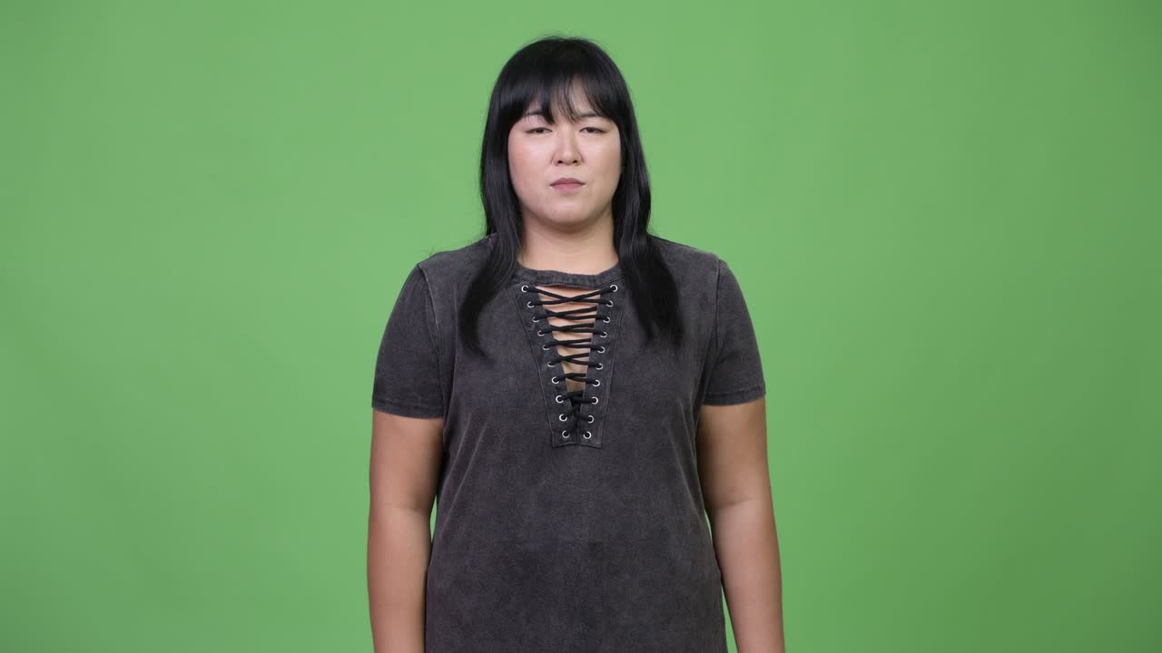 Happy overweight Asian woman giving thumbs up