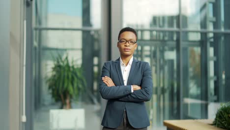 portrait of confident serious african american business woman standing with arms crossed looking at camera. outdoors
