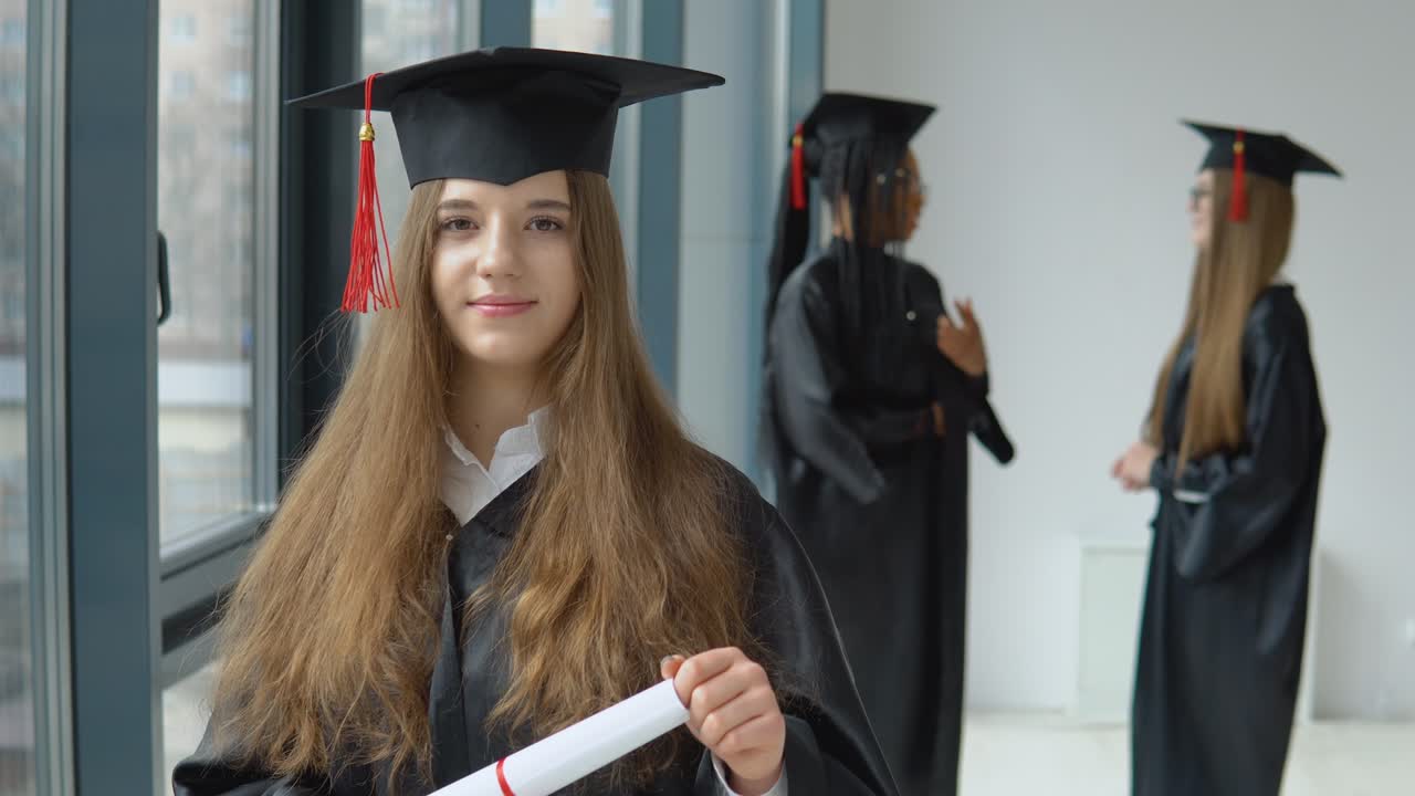 estudiantes de diferentes nacionalidades en el vestíbulo de la universidad. maestro de ciencias sociales. un graduado universitario en túnica de maestro con un diploma de educación superior está de pie frente a la cámara