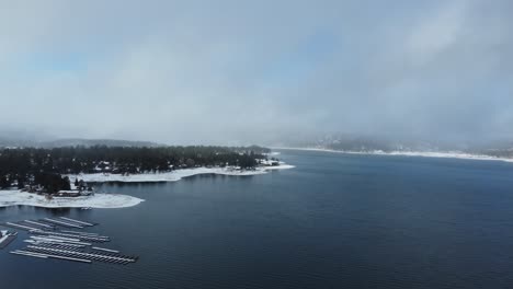 aerial view of big bear lake, california usa on cold winter day, alpine water and snowy landscape with rainbow, panorama