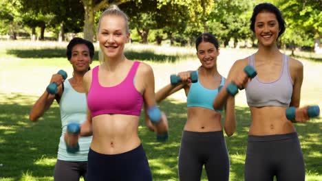clase de fitness golpeando con pesas manuales al unísono