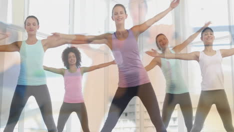fitness instructor leading group performing aerobics in studio, with animated heart rate graph