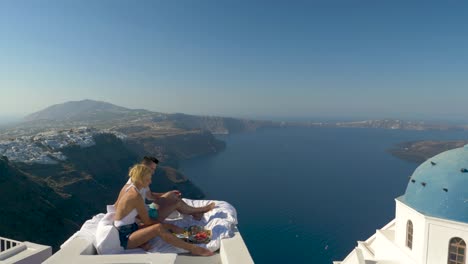 Young couple having rooftop breakfast amazing view Santorini Greece