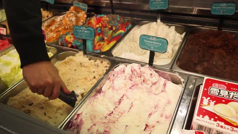 hand scooping ice cream from a display