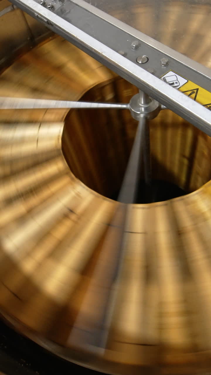 Opened lid to a metal barrel machine for honey extraction. Frames with honeycombs are rotated in the centrifuge apparatus. Top view. Vertical video