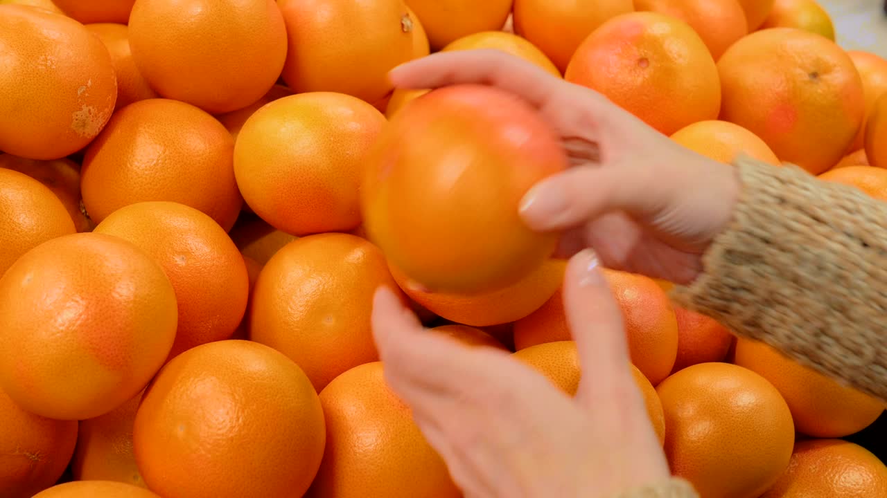 식료품 가게 에서 신선 한 그레이프프루트 를 구입 하는 여자