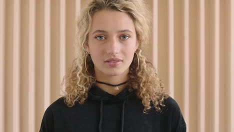 close-up-portrait-of-cute-young-blonde-woman-looking-pensive-shy-at-camera-vulnerable-femining-female-wearing-black-hoodie