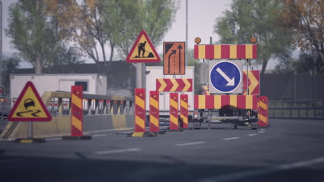 traffic barriers and signage indicating road construction in a suburban area