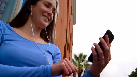 hermosa mujer joven feliz escuchando música en el teléfono móvil 4k