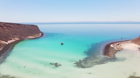 Aerial:-tropical-Mexican-Pacific-coastal-bay,-yacht-moored-in-turquoise-water