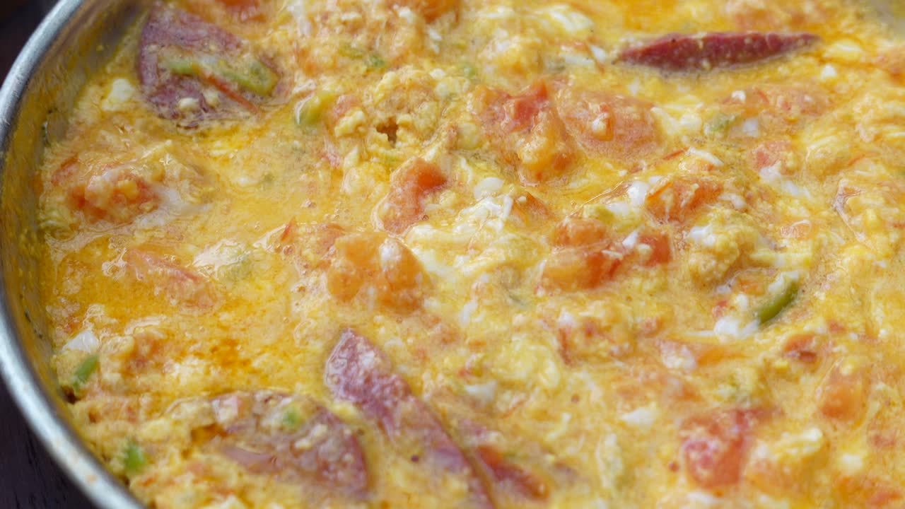 deliciosos menemen turcos: huevos revueltos con tomates y salchichas