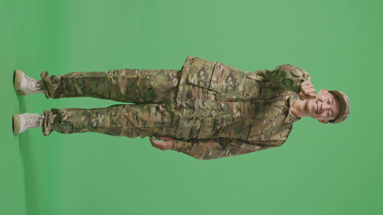 Full Body Of Asian Man Soldier Smiling And Touching His Chest Then Pointing At You While Standing In The Green Screen Background Studio