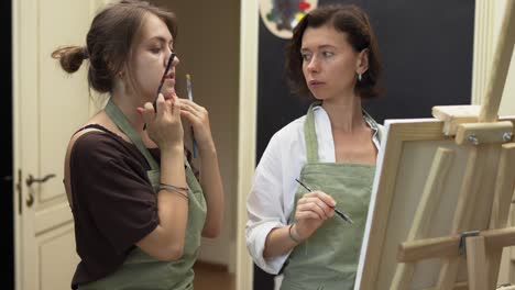 estudiante y profesor de arte durante la lección de pintura