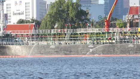 a vibrant urban scene featuring a crane, trees, and waterfront activity on a clear day.