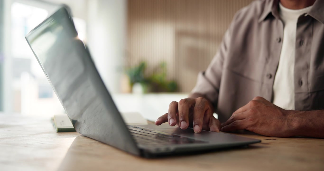 Man Using Laptop Trackpad in Bright Modern Office