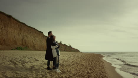 couple cuddling beach sea on holiday. happy mixed race lovers hug at ocean shore