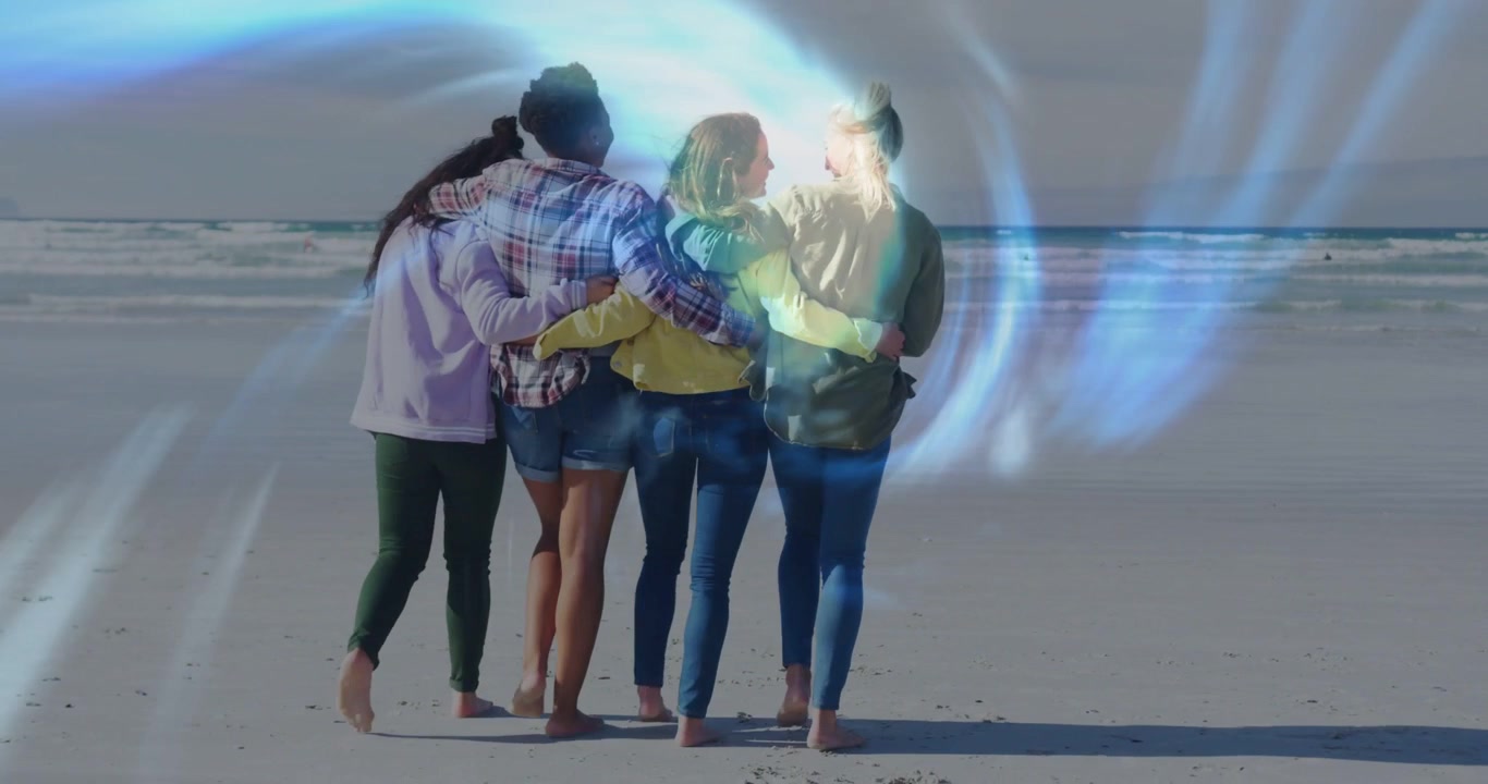 Video verticale: 4 donne a braccetto che camminano sulla sabbia bagnata dopo l'apparizione di un vortice blu per marketing.