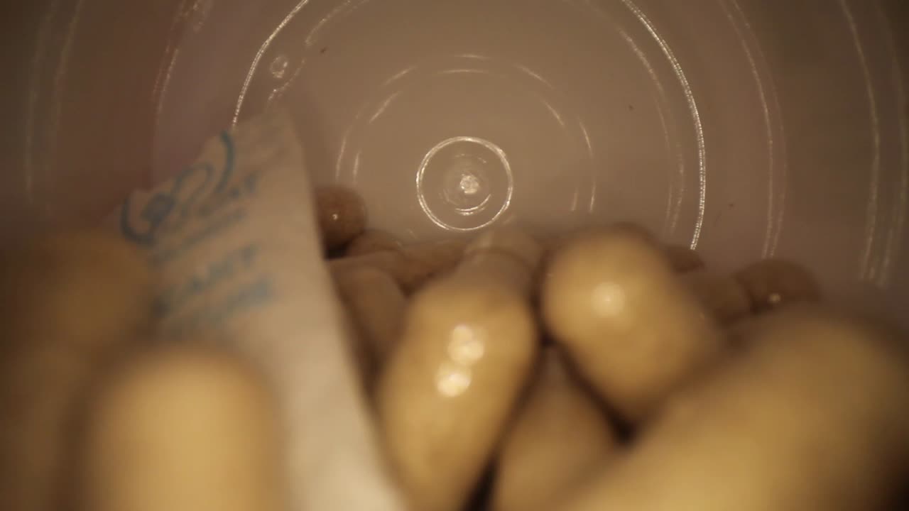 slowly moving out of the entire length of a supplement pill bottle with desiccant still in, revealing bottle's cap