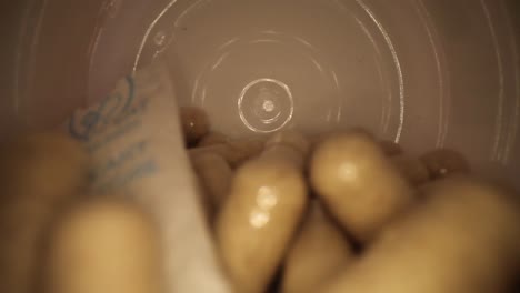 saliendo lentamente de toda la longitud de un frasco de píldoras suplementarias con desecante todavía adentro, revelando la tapa del frasco