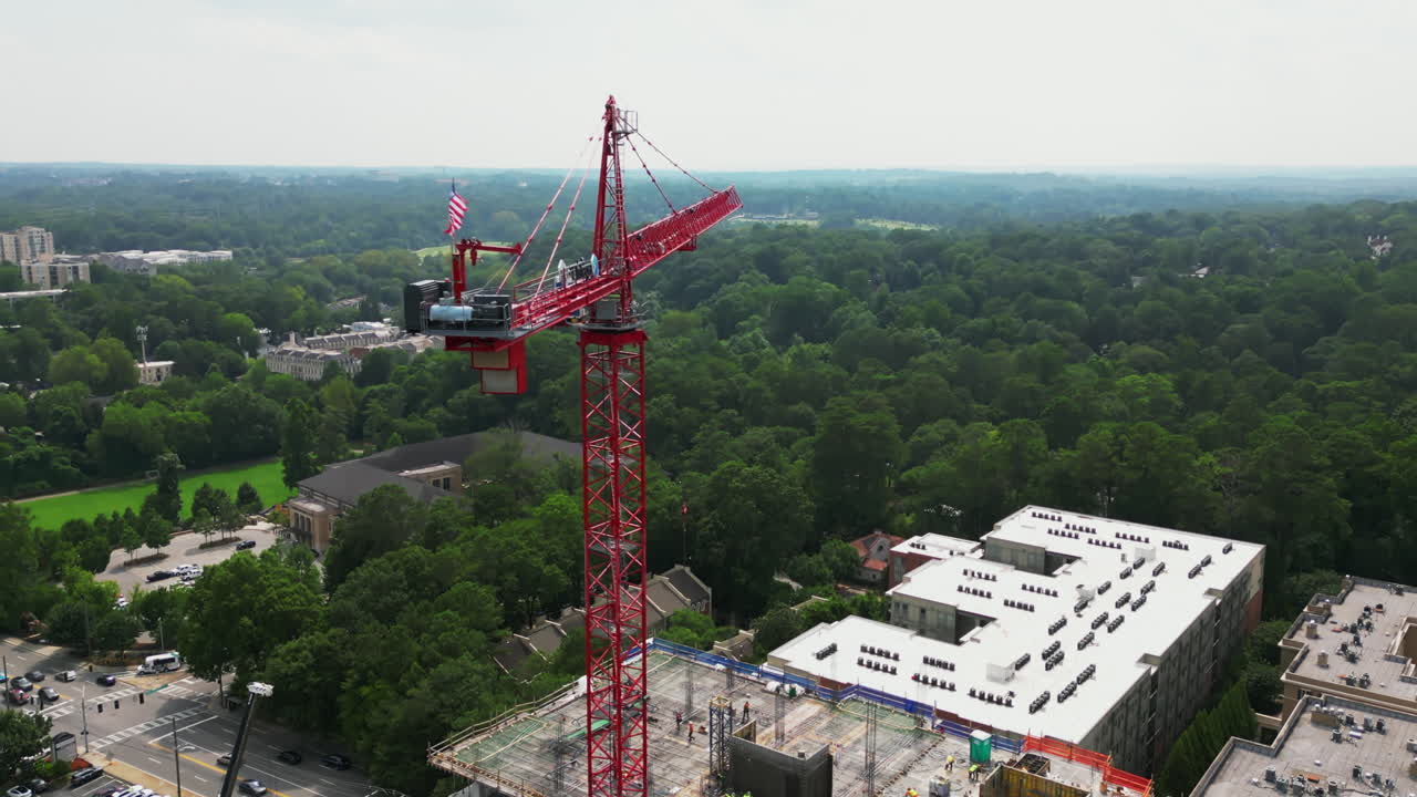 Aerial view of tall crane on construction site in urban neighbourhood