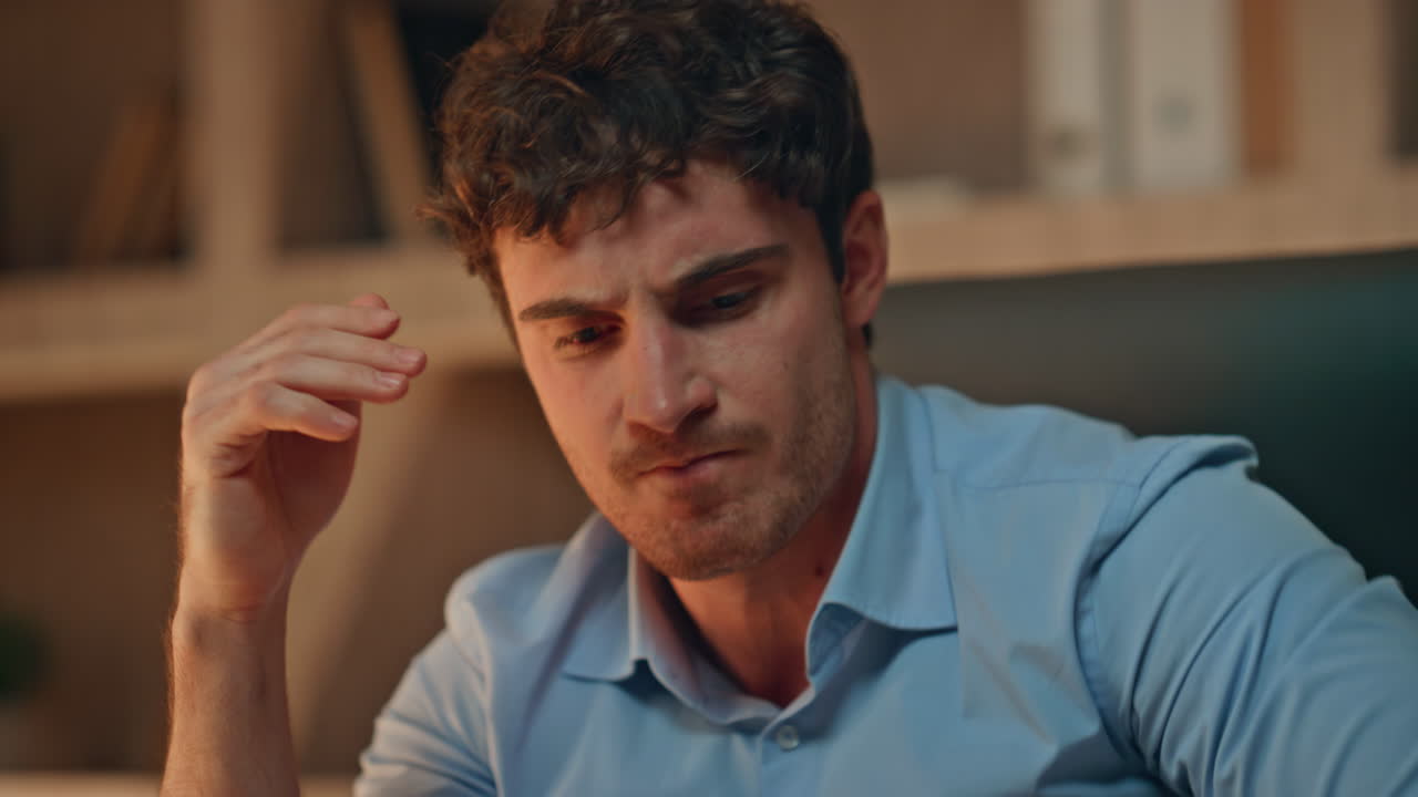 Aggressive businessman throwing papers on work desk late evening close up.