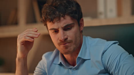 aggressive businessman throwing papers on work desk late evening close up.