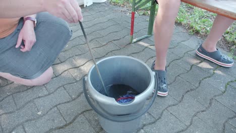 Batiks:-Boy-throws-a-T-shirt-into-a-bucket-of-liquid