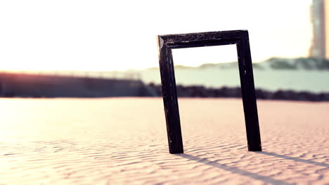 Empty-wooden-picture-frame-on-the-beach-sand