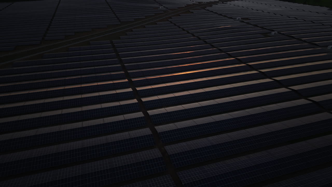 Cinematic drone footage of a structured solar panel field under a glowing sunset. Shot in Bulgaria, this footage emphasizes sustainability, climate progress, and modern energy solutions.