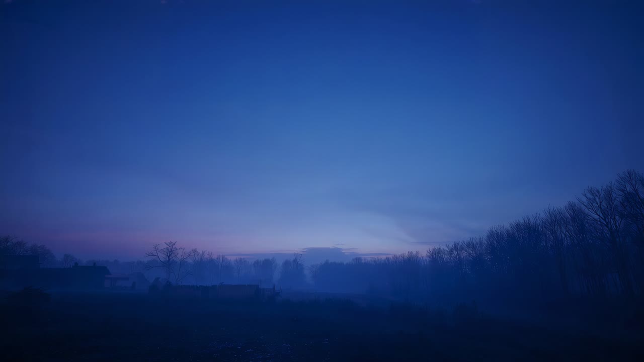 Brightening pre-dawn sky and distant treeline bathing rural meadow with low mist as sun rising