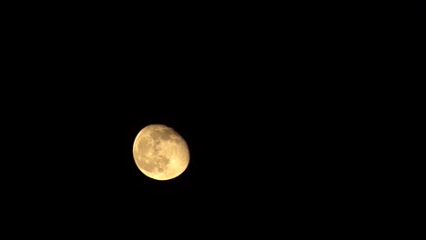 Time-Lapse-of-Moon-rising-from-bottom-left-corner-of-frame-to-top-right-frame-on-dark-background